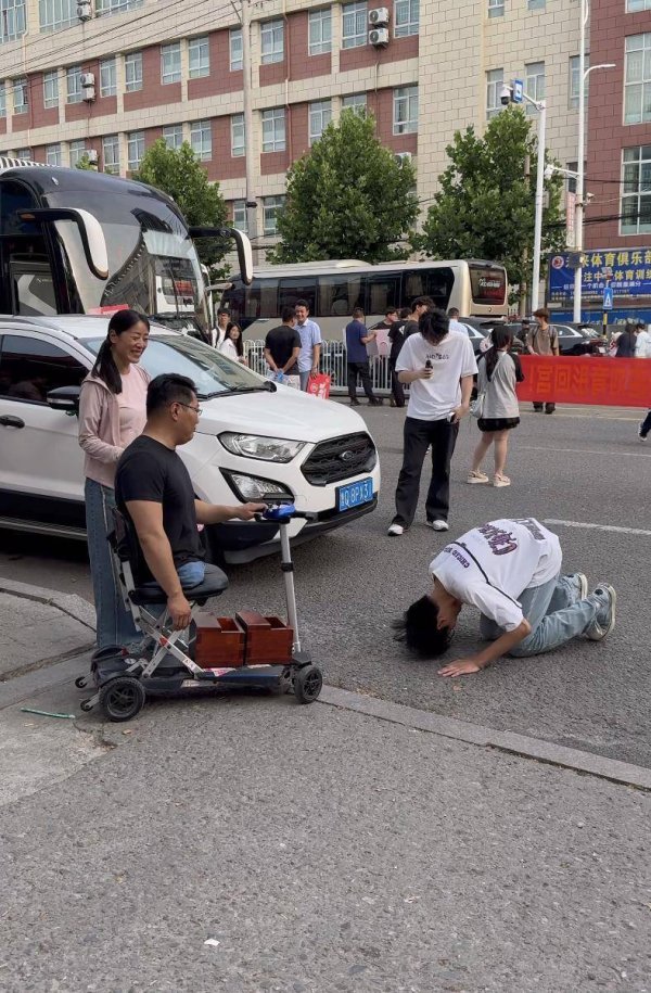 拉伯配资 考场外跪谢无腿父亲的男生高考成绩公布，父亲：很满意，儿子想去当兵